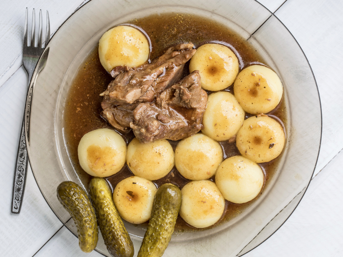 Kluski śląskie - propozycja podania, z mięsem, sosem i ogórkami kiszonymi.