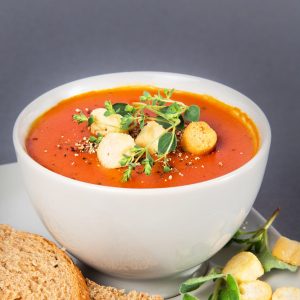 Zupa krem z pomidorów Podana z grzankami, świeżymi ziołami i czarnym pieprzem.