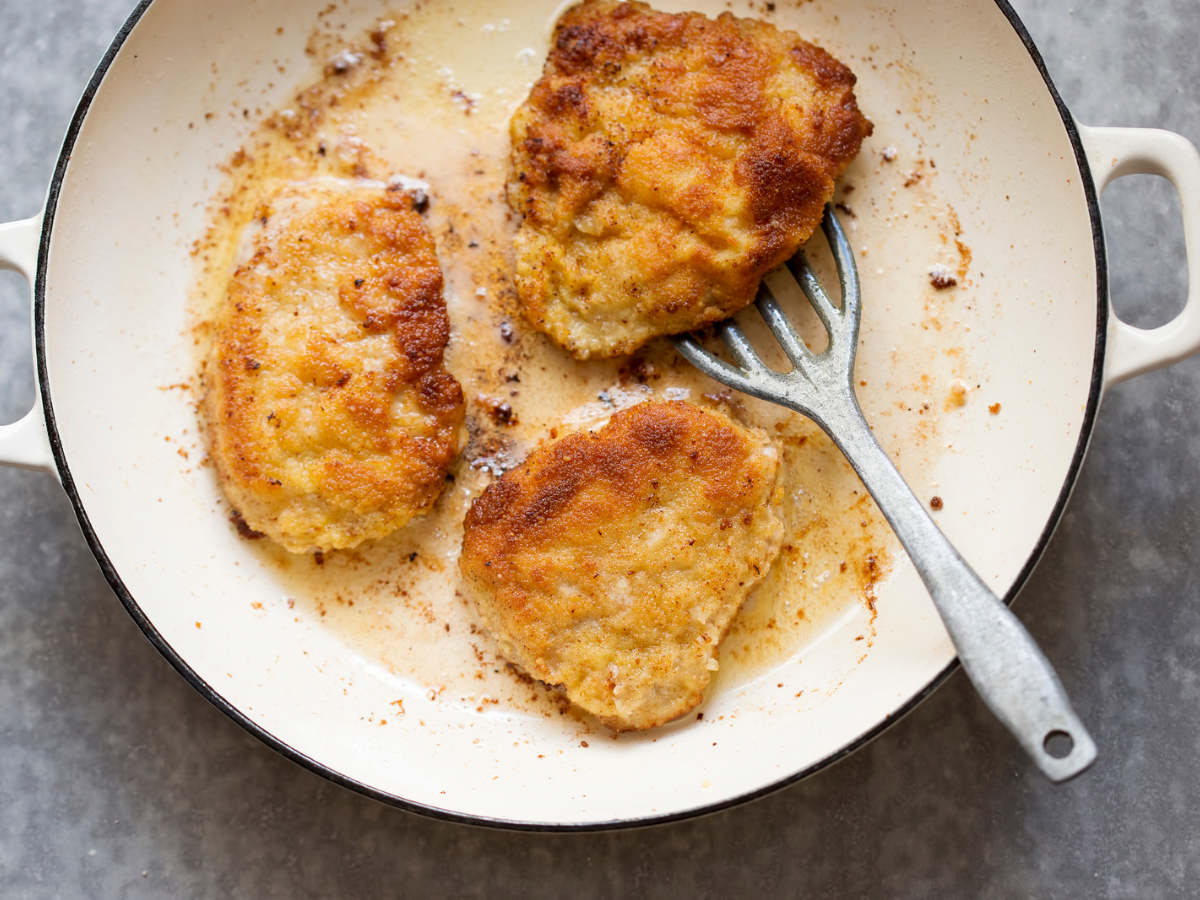 Kotlet Schabowy (Polish Breaded Pork Chop) 3 Kotlety schabowe (fried pork chops) on a pan frying