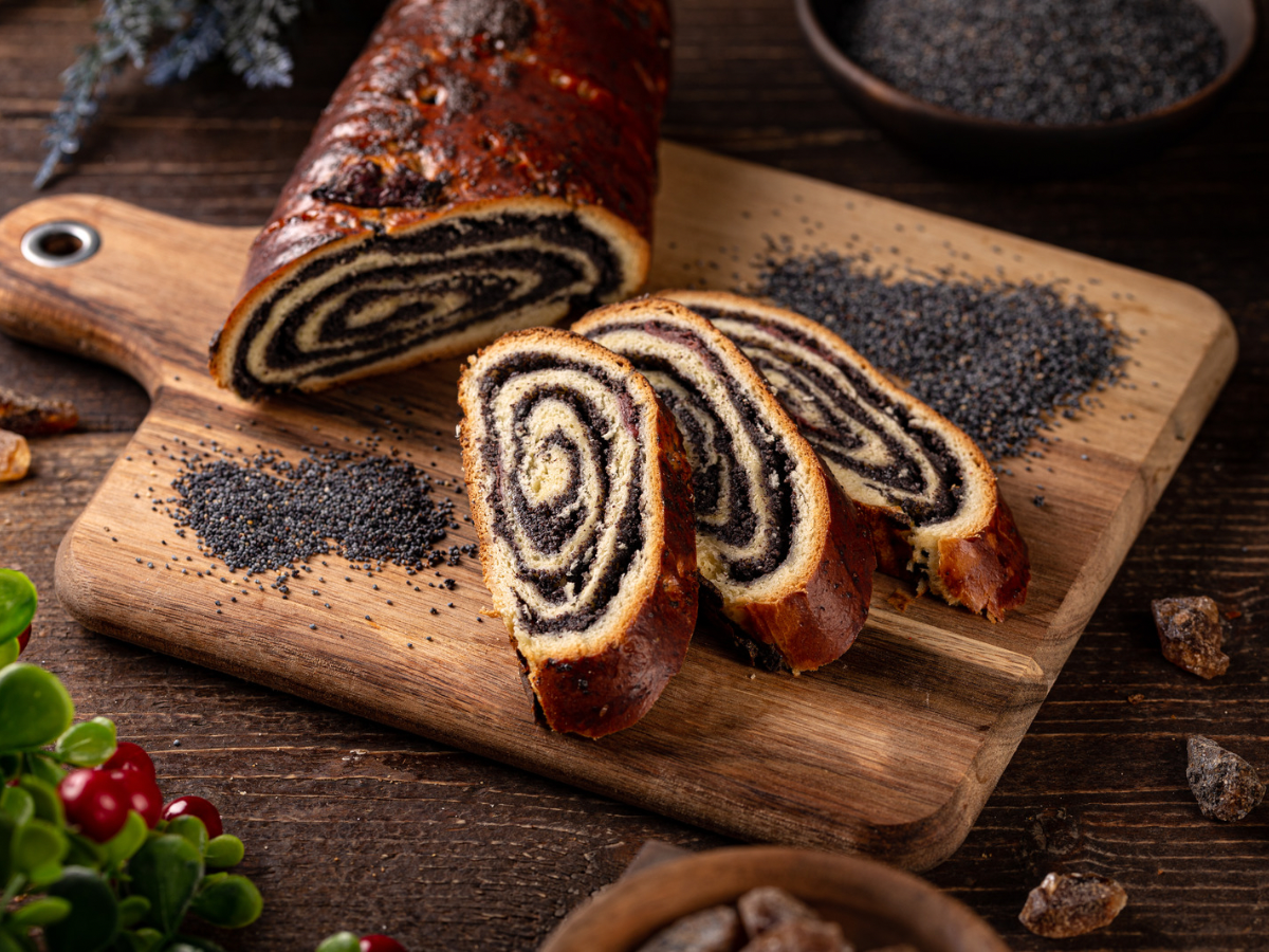 Polish Poppy Seed Roll Recipe (Makowiec) 2 Baked makowiec roll with poppy seeds on a cutting board.