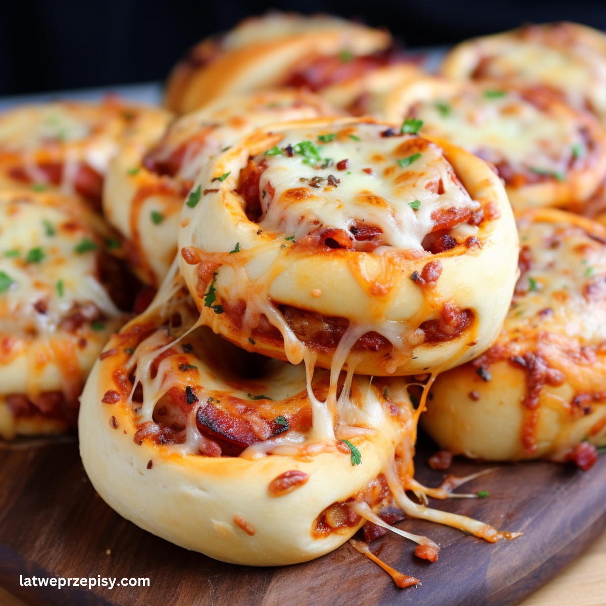 Bułeczki pizzowe Z pepperoni i mozzarellą, podane na drewnianej desce.